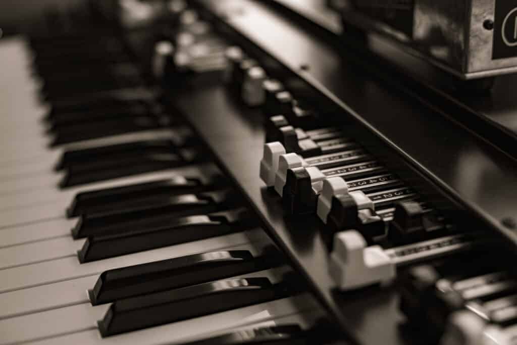 Clavier et registres d'orgue vintage en sépia. Touches noires/blanches et tirants numérotés 1 à 5.